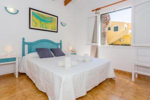 a bedroom with a bed with white sheets and a window at Son Xoriguer 5 in Son Xoriguer +19 photos