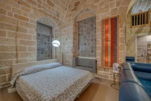 a bedroom with a bed and a stone wall at San Leonardo Apartments in Lecce