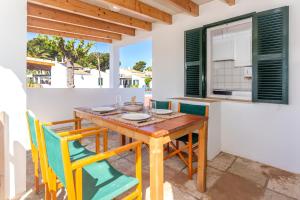 a dining room with a wooden table and chairs at Son Xoriguer 5 in Son Xoriguer