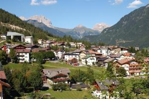 a village in a valley with mountains in the background at Roda A Parte in Vigo di Fassa
