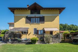 a yellow house with a window and a fence at Tinas yellow home in Leggiuno