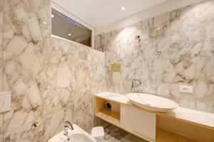 a white bathroom with a sink and a mirror at Roda A Parte in Vigo di Fassa +19 photos