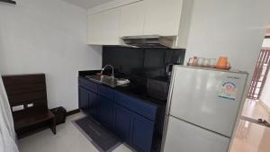 a kitchen with a refrigerator and a sink at joyful the Kris202 in Ban Lum Fuang