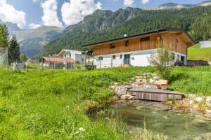a house in a field with a creek at Kwelle zur Natur Rehwiese in Obernberg am Brenner