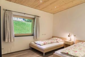 two beds in a room with a window at Kwelle zur Natur Rehwiese in Obernberg am Brenner