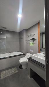 a bathroom with a toilet and a tub and a sink at joyful the Kris202 in Ban Lum Fuang