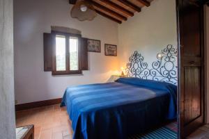 a bedroom with a bed with a blue blanket at La Casa dei Mandorli in Talamone +16 photos