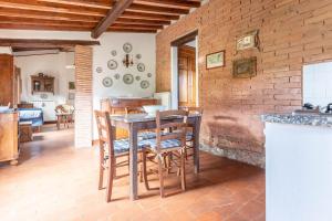 a kitchen with a table and chairs and a brick wall at La Casa dei Mandorli in Talamone