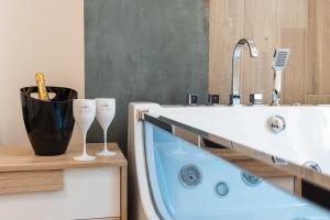a bathroom with a tub and two wine glasses at Suite N12 - Luxury Apartment in Bari +17 photos