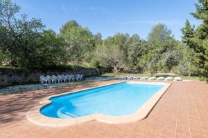 an image of a swimming pool with chairs and trees at La Xaconera in Catllar
