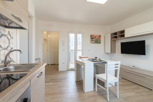 a kitchen with a sink and a table with a chair at Suite N12 - Luxury Apartment in Bari