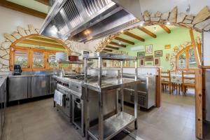a large kitchen with stainless steel appliances and a table at La Xaconera in Catllar