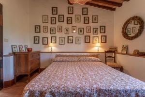 a bedroom with a bed and pictures on the wall at La Casa dei Mandorli in Talamone