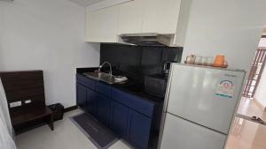 a small kitchen with a refrigerator and a sink at joyful the Kris202 in Ban Lum Fuang +4 photos