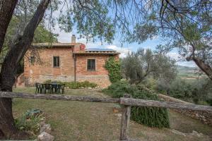a stone house with a fence in front of it at La Casa dei Mandorli in Talamone