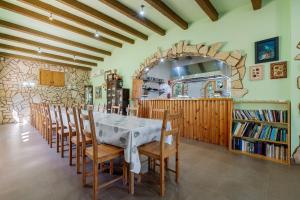 a dining room with a table and wooden chairs at La Xaconera in Catllar