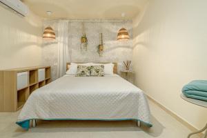 a bedroom with a bed and two lights on the wall at Dependance con piscina in Punta Molara +18 photos