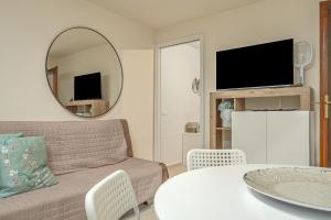 a living room with a couch and a table and a mirror at Dependance con piscina in Punta Molara