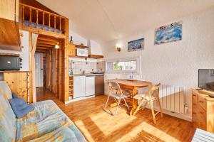 a kitchen and living room with a table and chairs at Appartement Avec Balcon St Honore in Saint-Honoré
