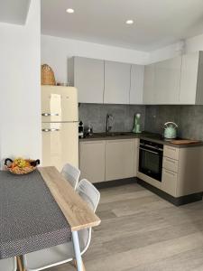 a kitchen with a table and a white refrigerator at Sofias House Fresh And Comfy in Naxos Chora +7 photos