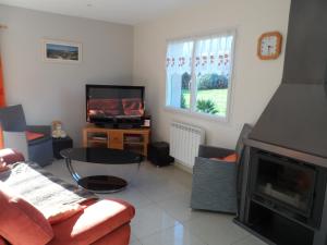 a living room with a couch and a fireplace at Gite bord de mer jacuzzi in Plougrescant