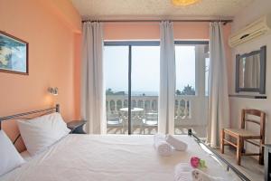 a bedroom with a bed and a large window at Andromaches apartment sea view in Corfu