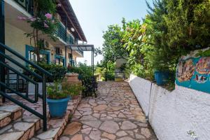 a stone walkway with potted plants on the side of a building at Andromaches apartment sea view in Corfu