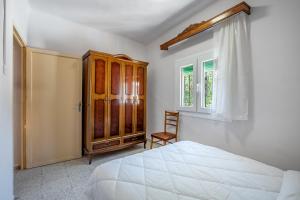 a bedroom with a bed and a wooden cabinet at Casa Juan y Loli in Nigüelas +32 photos