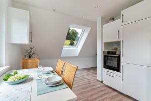 a kitchen and dining room with a white table and chairs at Haus 23 in Ettenheim