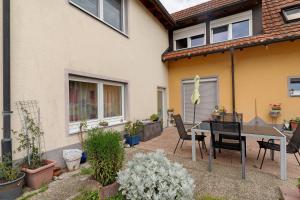 a patio with a table and chairs in front of a house at Nichtraucher-Ferienwohnung Sandhaas in Ringsheim