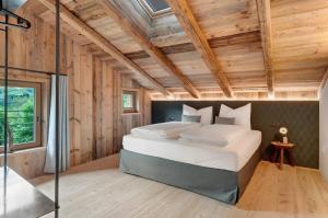 a bedroom with a large bed in a room with wooden walls at Chalet’s Samer in Sarntal