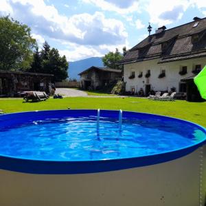 a large blue pool in a yard with a house at Oberwieserhof App 3 in San Lorenzo di Sebato