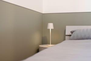 a bedroom with a white bed and a lamp at Apartment 5 in Rielasingen-Worblingen