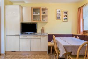 a living room with a table and a television at Oberwieserhof App 3 in San Lorenzo di Sebato