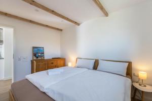 ein Schlafzimmer mit einem großen weißen Bett und zwei Lampen in der Unterkunft Holtdeel in Gelting