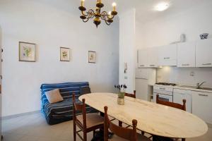 a kitchen and dining room with a table and a couch at Casa Edda - Sea view in Diano Marina