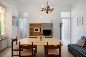 a dining room with a table and chairs and a couch at Casa Edda - Sea view in Diano Marina