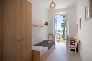 a bedroom with a bed and a door to the ocean at Casa Edda - Sea view in Diano Marina
