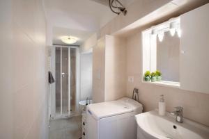 a white bathroom with a sink and a washing machine at Casa Edda - Sea view in Diano Marina +15 photos