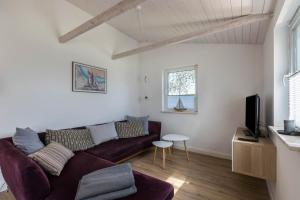 ein Wohnzimmer mit Sofa und Fernseher in der Unterkunft Holtdeel in Gelting