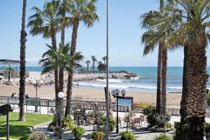 a view of a beach with palm trees and the ocean at Casa Edda - Sea view in Diano Marina
