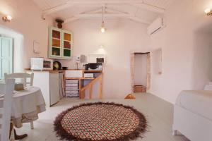 a living room with a kitchen and a rug on the floor at Sira Stonehouse lll in Volímai +20 photos