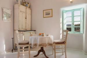 a table and chairs with a table and a window at Sira Stonehouse lll in Volímai