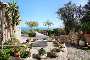 a garden with many potted plants on a sidewalk at Sira Stonehouse lll in Volímai