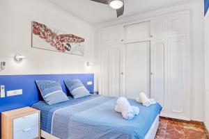 a blue and white bedroom with two towels on a bed at Perla del Mar Calpe in Benissa +32 photos