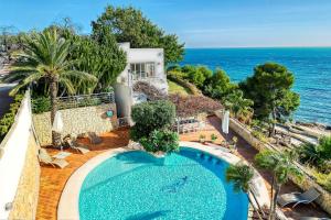 an aerial view of a house with a swimming pool and the ocean at Perla del Mar Calpe in Benissa