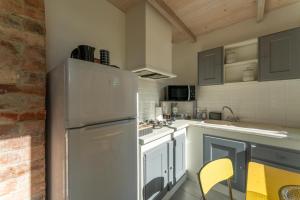 a kitchen with white cabinets and a refrigerator at Studio à la campagne in Sarrians