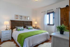 a bedroom with a large bed with a green blanket at Casa Vereda del Risco in Ye