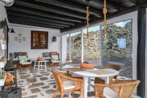 a patio with a table and chairs on a stone floor at Casa Vereda del Risco in Ye