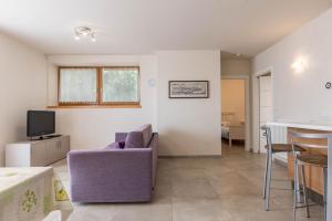 a living room with a purple chair and a table at Casa Weekend in Revò